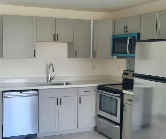 a kitchen with white cabinets and stainless steel appliances