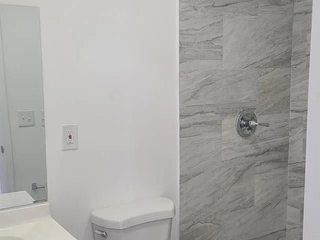 a bathroom with a toilet and a shower