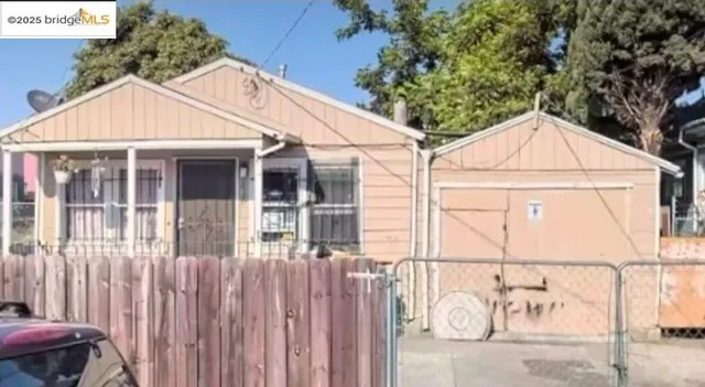 a view of a white house with large windows and a small yard