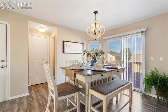 712 Rye Ridge Road Fountain, CO 80817 - Photo 12 of 45 Dining space featuring dark wood-style flooring and a chandelier