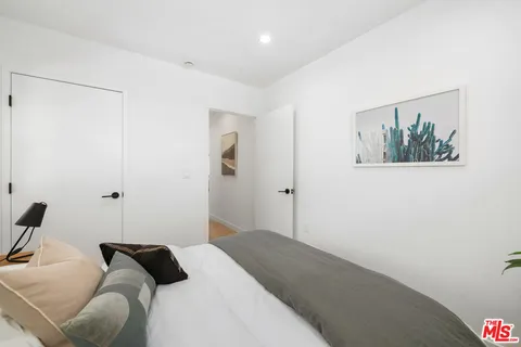 a view of a hallway with wooden floor and closet
