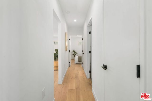 a bedroom with a large bed and a potted plant