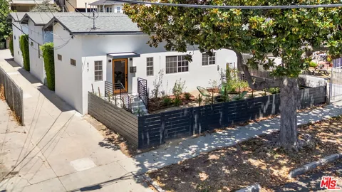 a front view of a house with cars parked