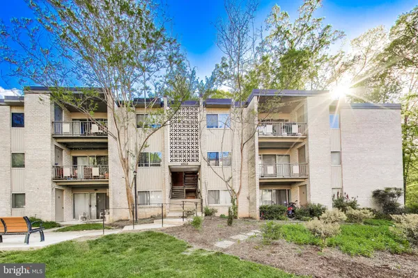 a view of a brick house with a yard and plants