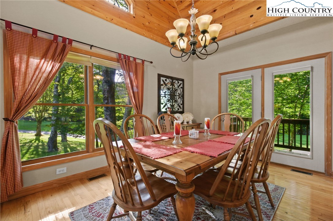 105 Old Field Road Beech Mountain, NC 28604 - Photo 19 of 43 a view of a dining room with furniture a chandelier and wooden floor