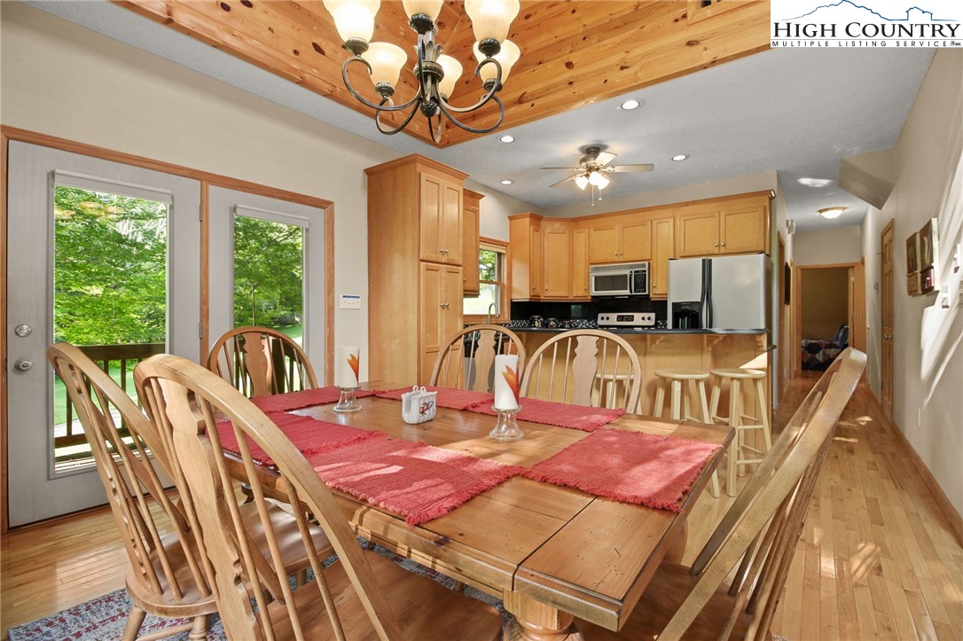 105 Old Field Road Beech Mountain, NC 28604 - Photo 20 of 43 a view of a dining room with furniture a chandelier and wooden floor
