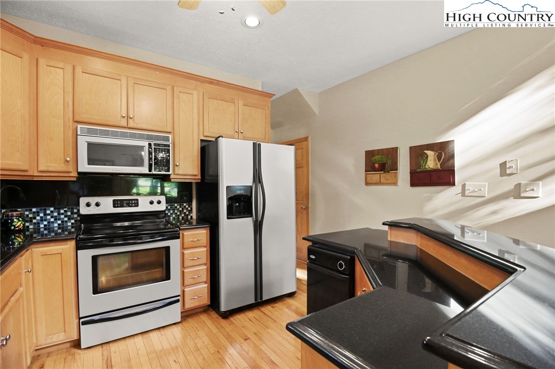 105 Old Field Road Beech Mountain, NC 28604 - Photo 23 of 43 a kitchen with stainless steel appliances granite countertop a refrigerator stove and sink