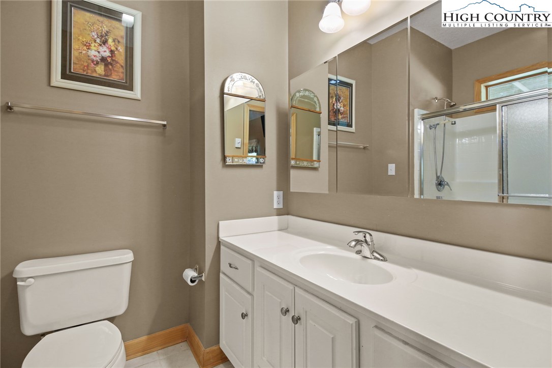 105 Old Field Road Beech Mountain, NC 28604 - Photo 38 of 43 a bathroom with a toilet a sink and mirror