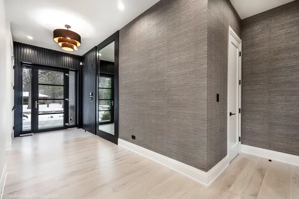an empty room with entryway and wooden floor