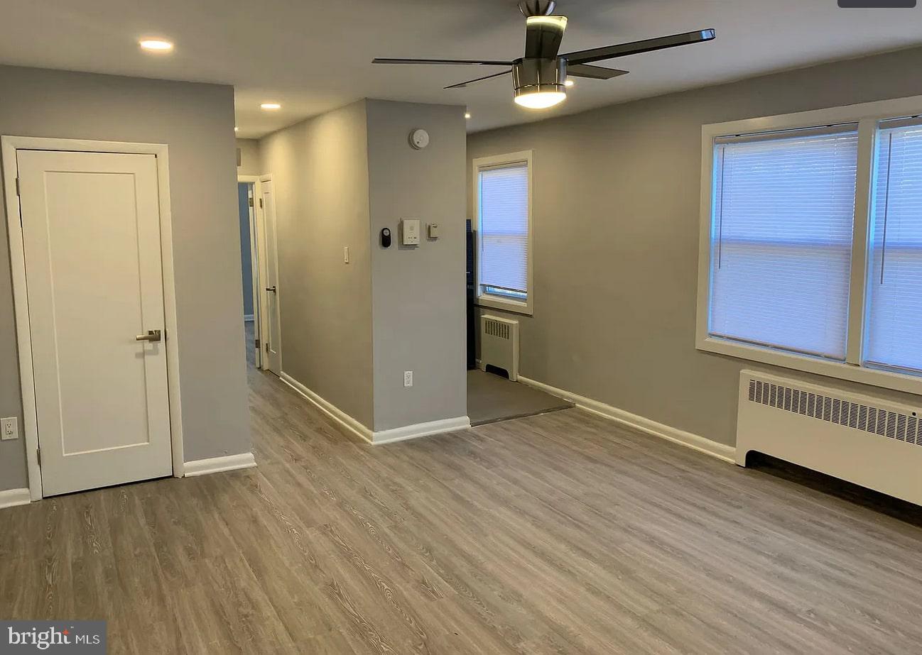 6644 North 8th Street, Unit A4 Philadelphia, PA 19126 - Photo 2 of 9 an empty room with wooden floor cabinet and windows