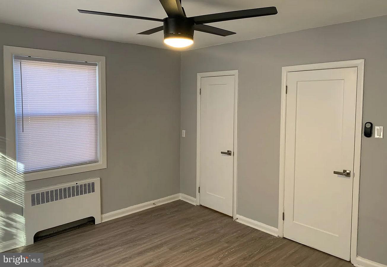 6644 North 8th Street, Unit A4 Philadelphia, PA 19126 - Photo 6 of 9 an empty room with wooden floor cabinet and windows