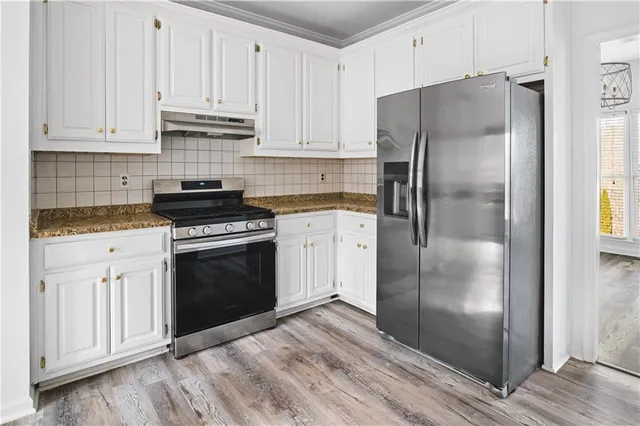 a kitchen with white cabinets and stainless steel appliances