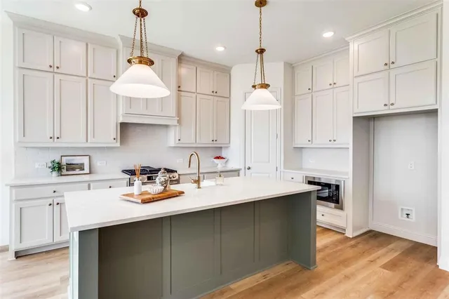 a kitchen with kitchen island granite countertop a sink a center island and cabinets
