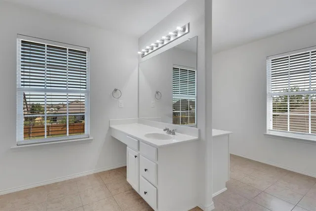 a room with a sink cabinets and a window