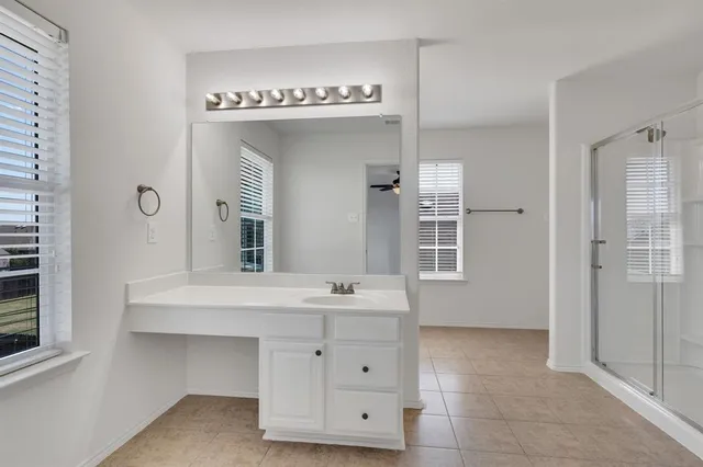 a bathroom with a sink a mirror and a shower