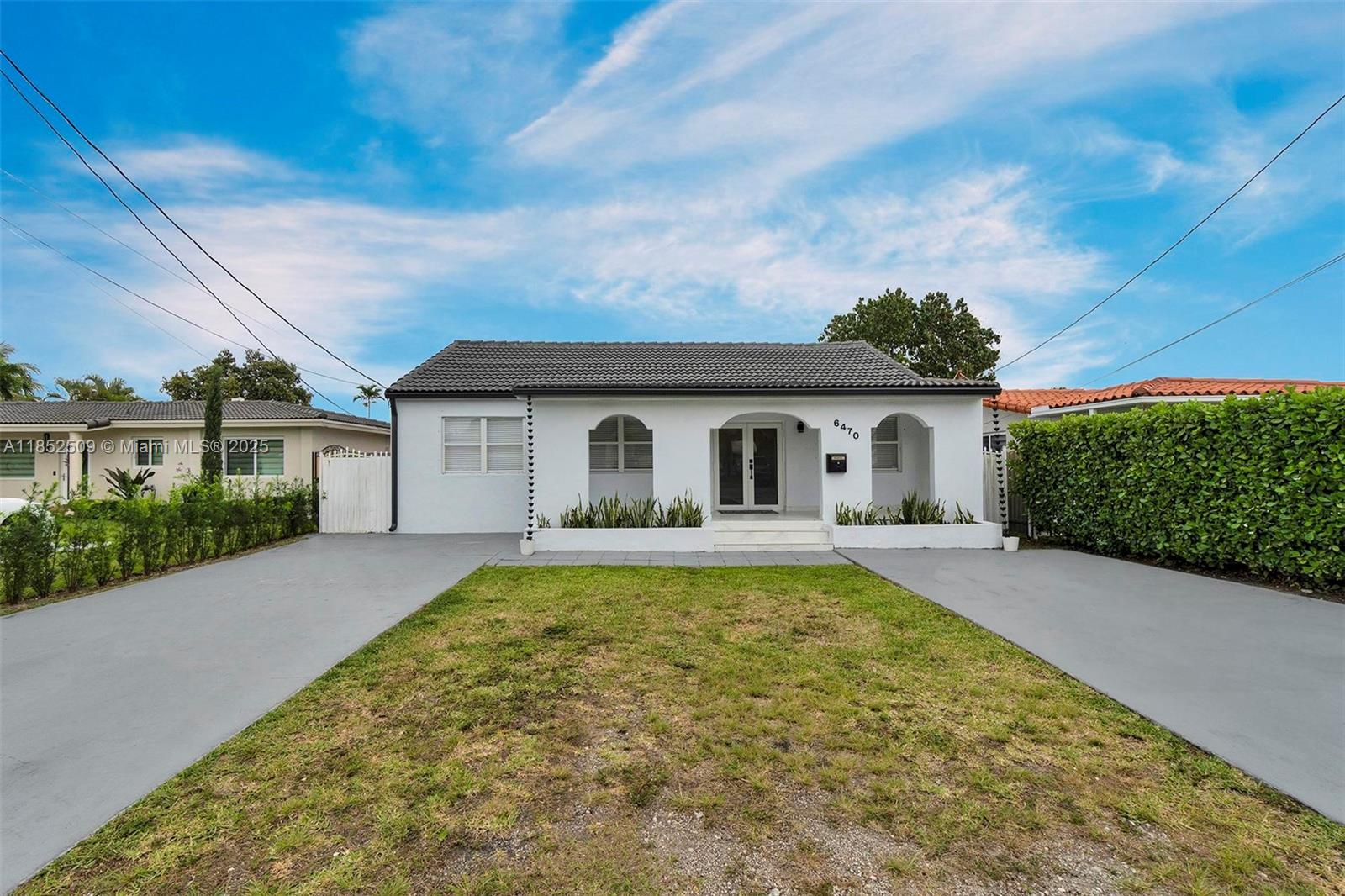 a front view of house with yard and trees in the background
