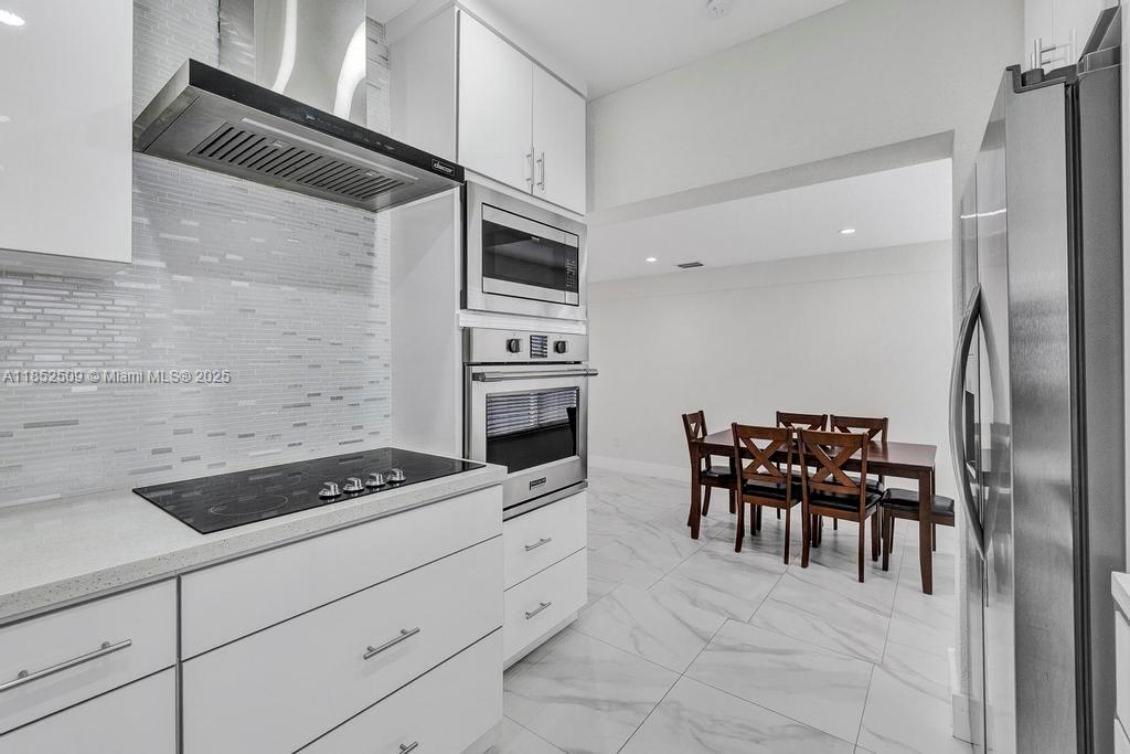 6470 Southwest 27th Street Miami, FL 33155 - Photo 12 of 38 a kitchen with granite countertop a sink cabinets and stainless steel appliances