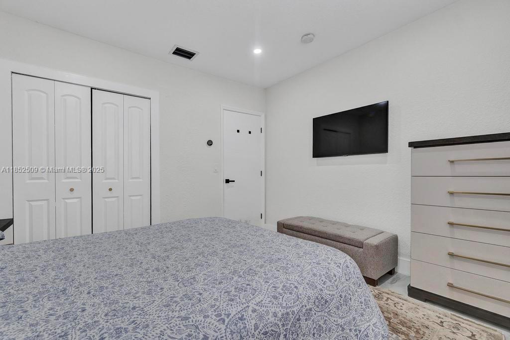 6470 Southwest 27th Street Miami, FL 33155 - Photo 14 of 38 a bedroom with a bed and a flat screen tv