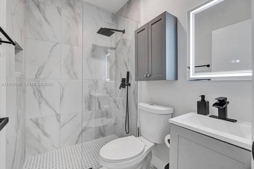 6470 Southwest 27th Street Miami, FL 33155 - Photo 15 of 38 a bathroom with a toilet sink vanity and shower