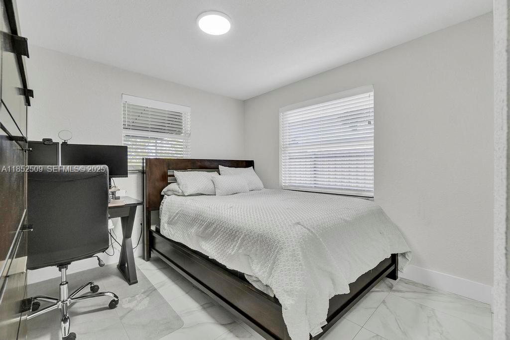 6470 Southwest 27th Street Miami, FL 33155 - Photo 18 of 38 a bed sitting in a bedroom next to a window