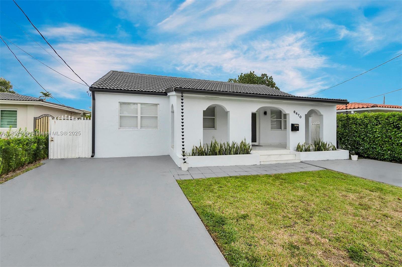 6470 Southwest 27th Street Miami, FL 33155 - Photo 2 of 38 a view of a white house with a big yard and potted plants