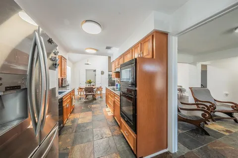 a kitchen with stainless steel appliances granite countertop a refrigerator and a stove
