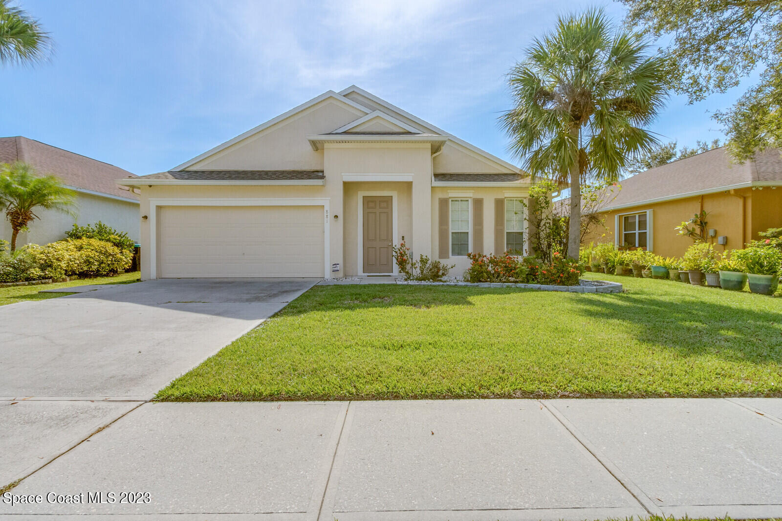 a front view of a house with a yard and trees