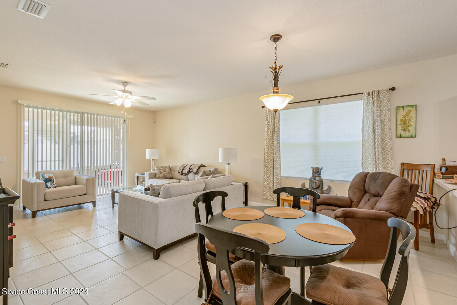 881 Benton Drive Melbourne, FL 32901 - Photo 11 of 34 a living room with furniture a table and a chandelier