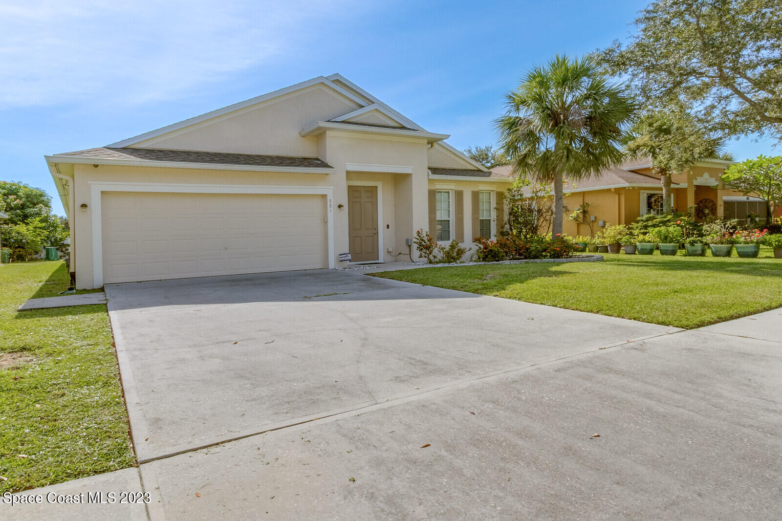 881 Benton Drive Melbourne, FL 32901 - Photo 2 of 34 a front view of a house with a yard and garage