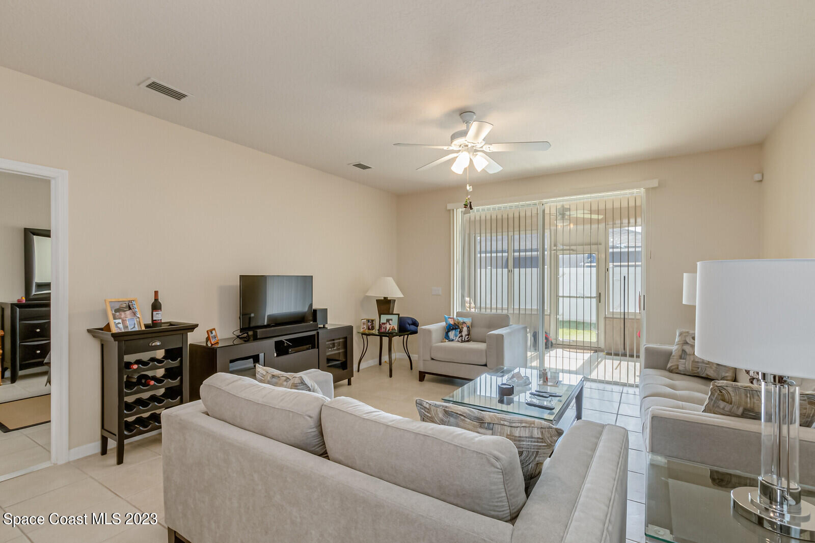 881 Benton Drive Melbourne, FL 32901 - Photo 22 of 34 a living room with furniture a flat screen tv and a large window