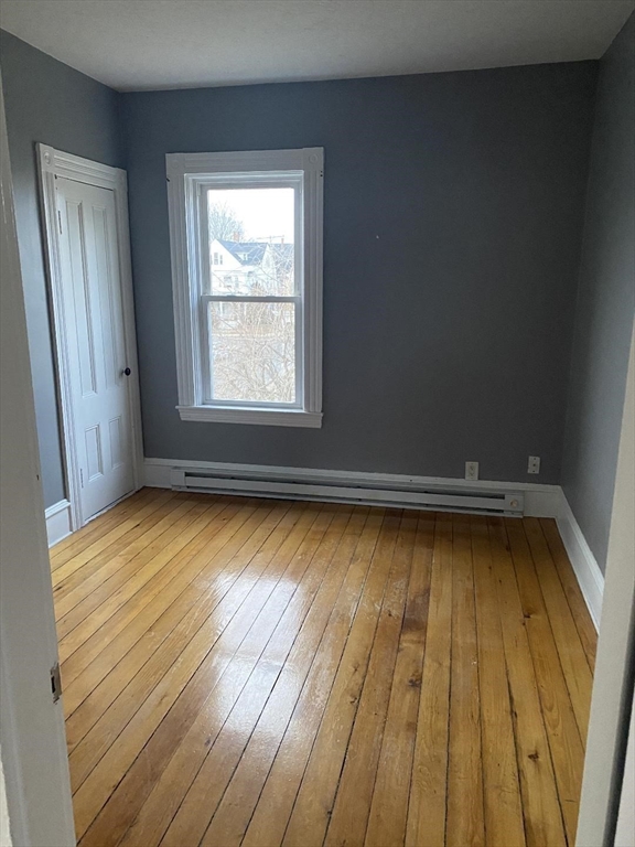 147 Stetson Street, Unit 2 Fall River, MA 02720 - Photo 8 of 8 an empty room with wooden floor and windows
