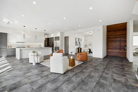 a large kitchen with kitchen island a large counter top stainless steel appliances and cabinets