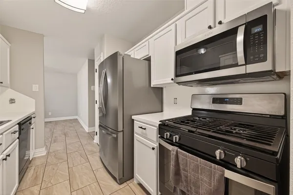 a kitchen with stainless steel appliances granite countertop a stove microwave and refrigerator