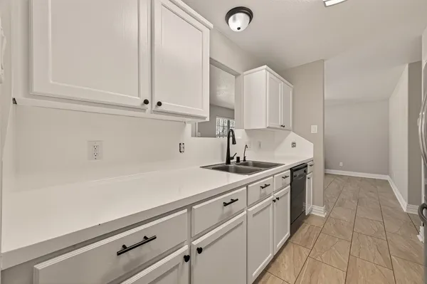 a kitchen with granite countertop white cabinets and white appliances