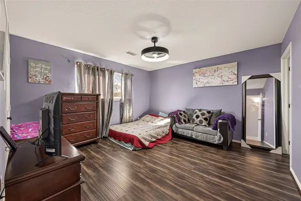 a bedroom with furniture and wooden floor
