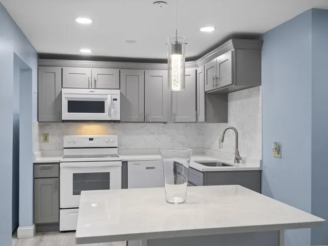 a kitchen with stainless steel appliances a sink a stove a microwave a sink a refrigerator and cabinets