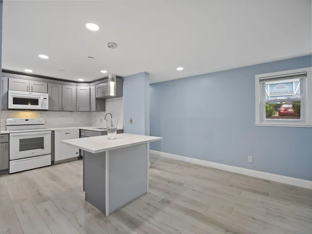 a kitchen with a sink cabinets and wooden floor