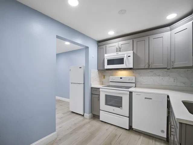 a kitchen with stainless steel appliances granite countertop a stove and a microwave