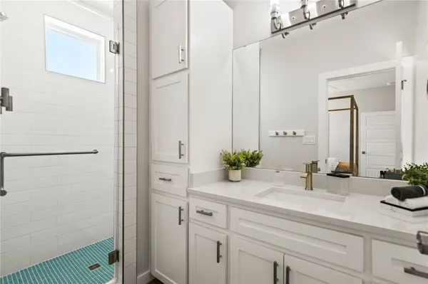 a bathroom with a sink and mirror with shower