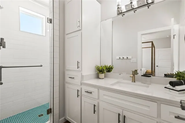 a bathroom with a sink and mirror with shower