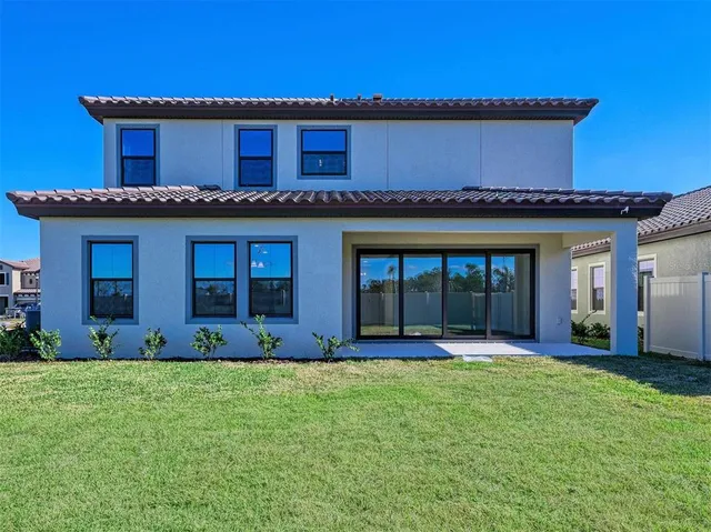 a view of a house with a yard chair and potted plants