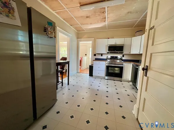 a kitchen with stainless steel appliances a refrigerator a stove a sink dishwasher and a refrigerator with wooden floor
