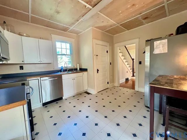 a kitchen with a sink a stove a refrigerator and cabinets