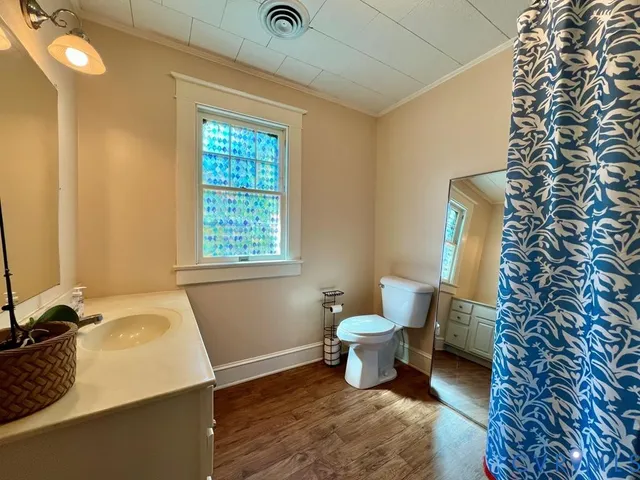 a bathroom with a sink toilet and window