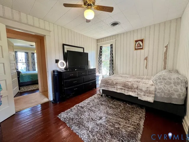 a bedroom with a bed and wooden floor