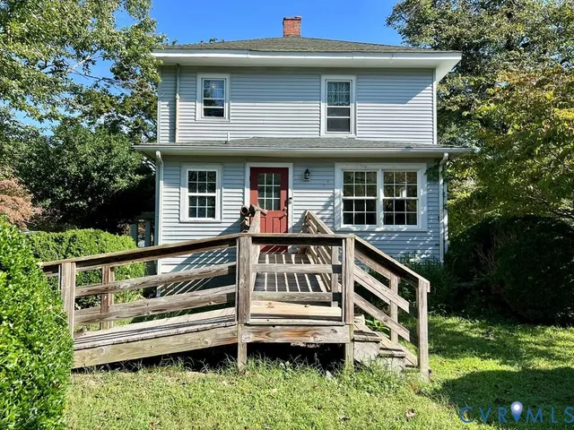 a view of house with roof deck and garden