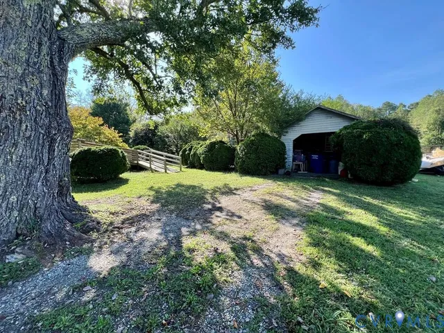 a view of a garden with a bench and trees