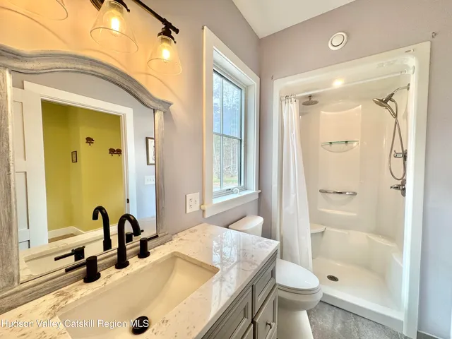 a bathroom with a granite countertop sink toilet and shower