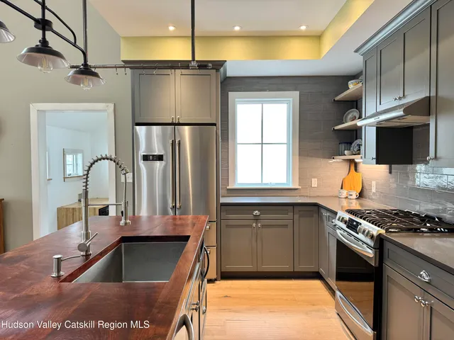 a kitchen with kitchen island granite countertop a stove and a sink