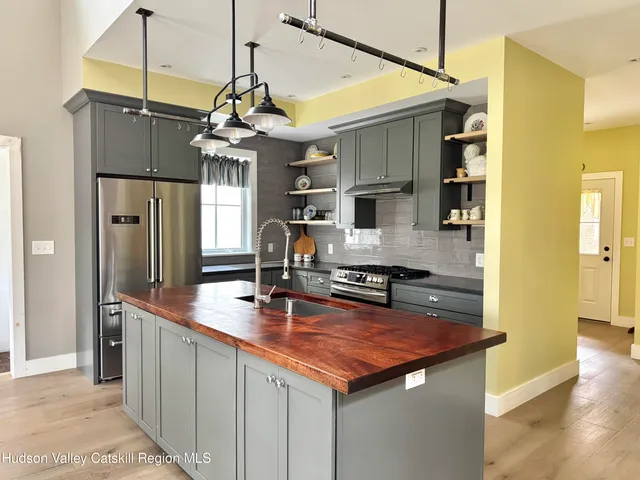a kitchen with stainless steel appliances granite countertop a sink a refrigerator and a stove